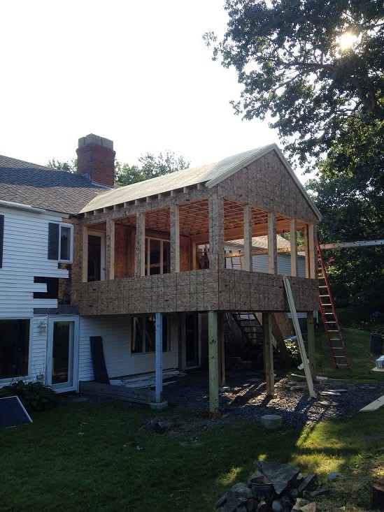 Elevated addition framed and sheathed over a new lower-level entry
