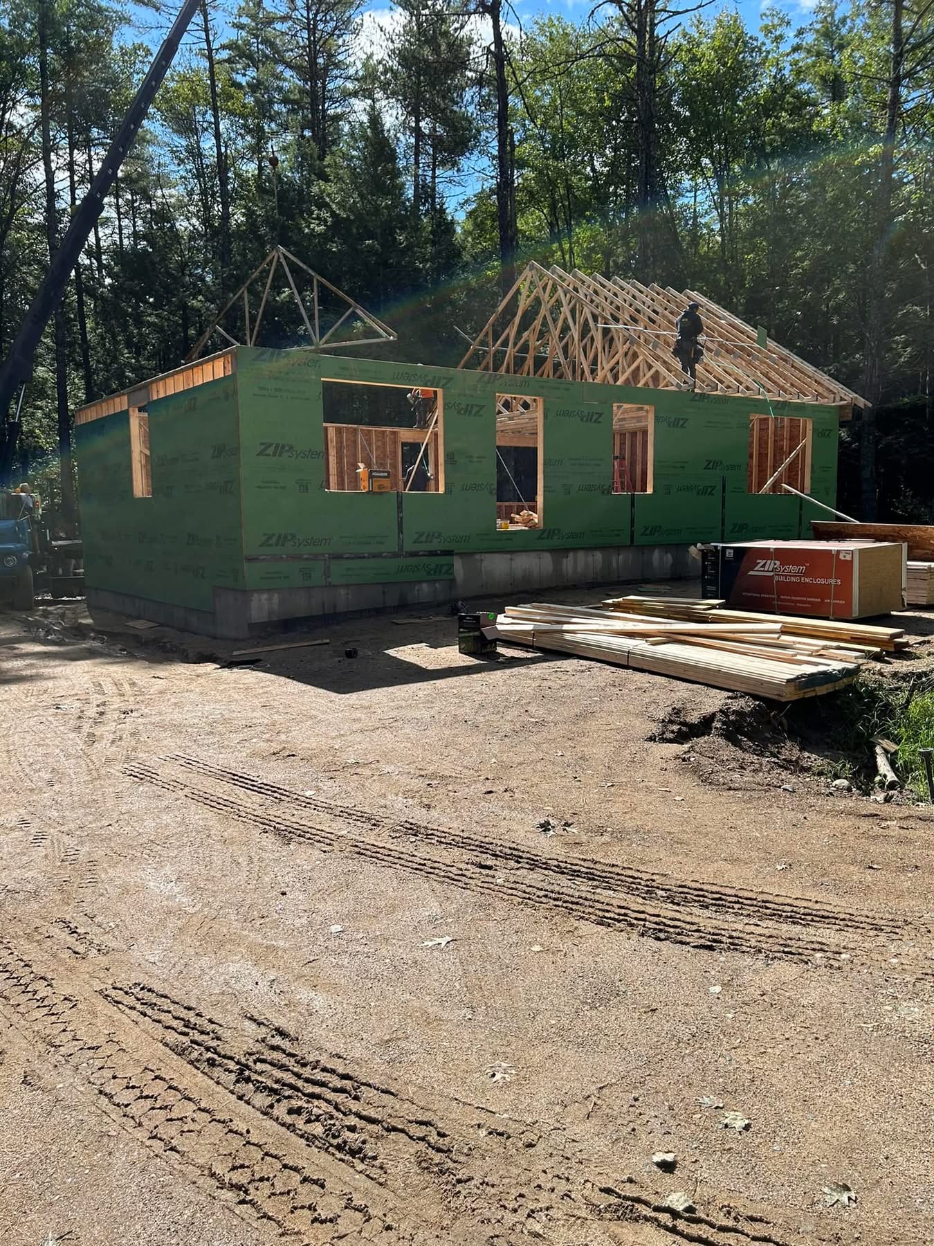 Ranch home framing with roof trusses set by crane
