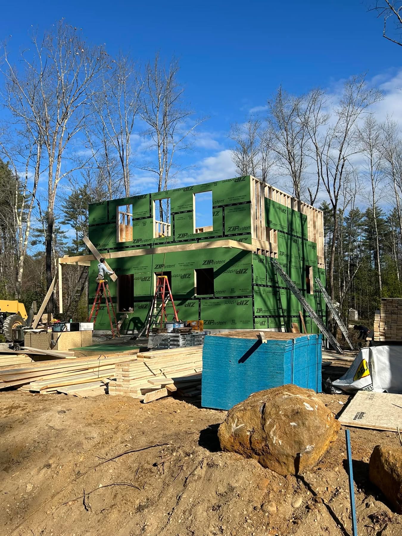 Two-story new home sheathed in ZIP System panels with porch framing underway