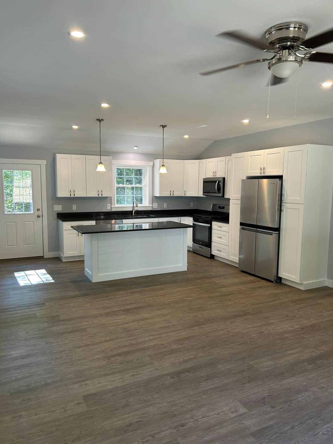 New kitchen with white cabinets, shiplap island, and granite countertops