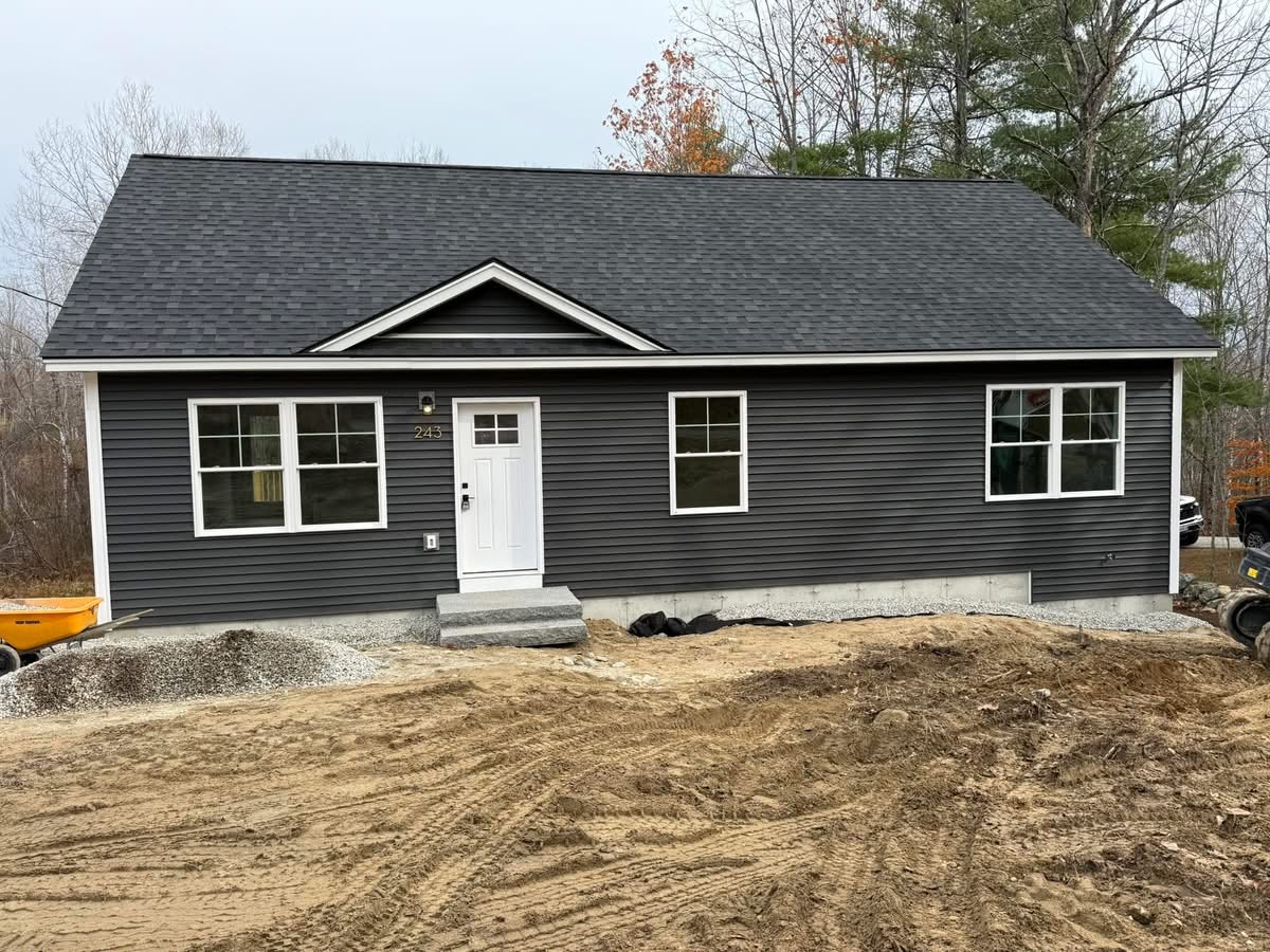 Newly completed gray ranch-style home with granite step and gable entry