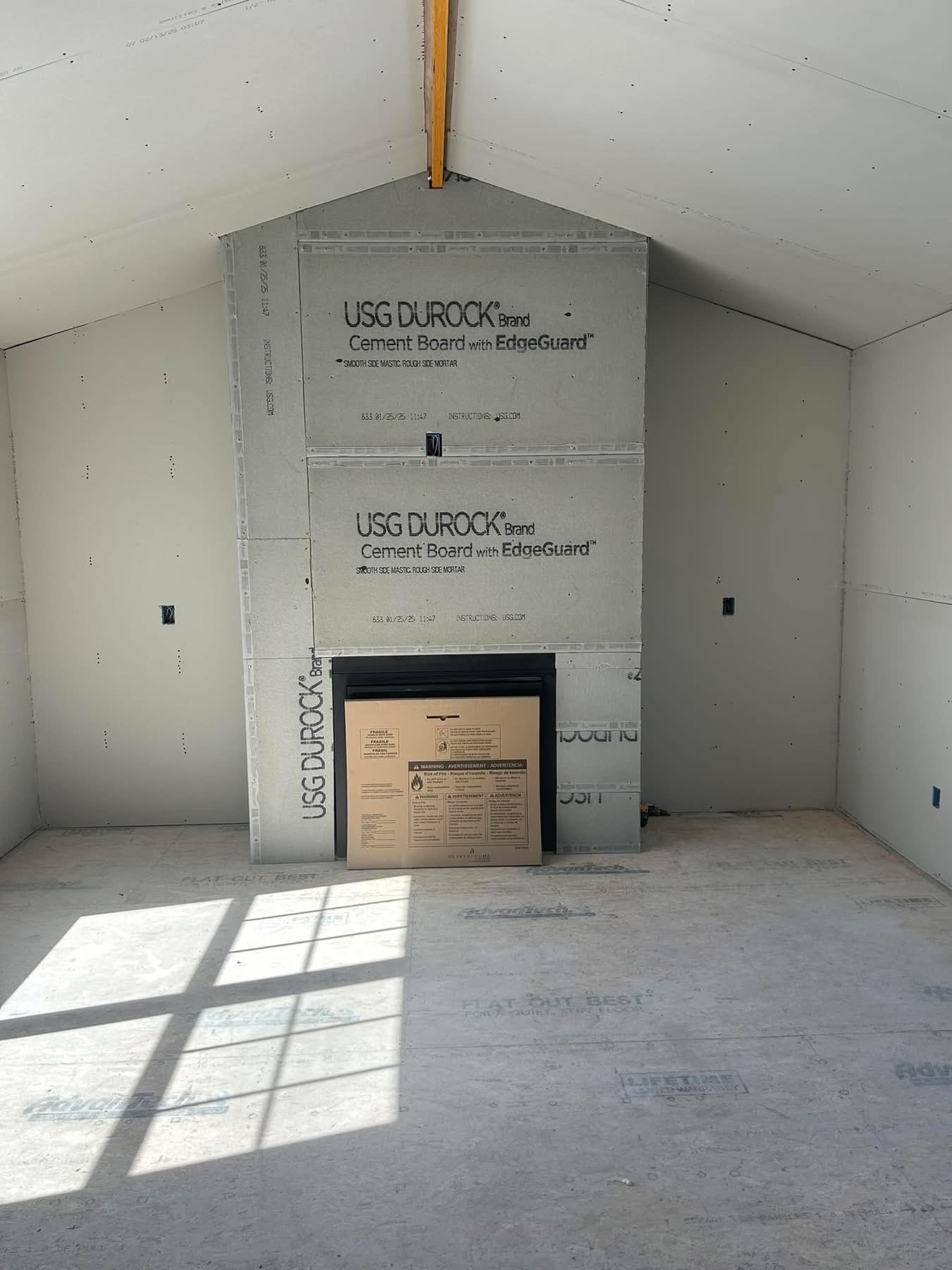 Interior great room with vaulted ceiling and cement-board fireplace surround