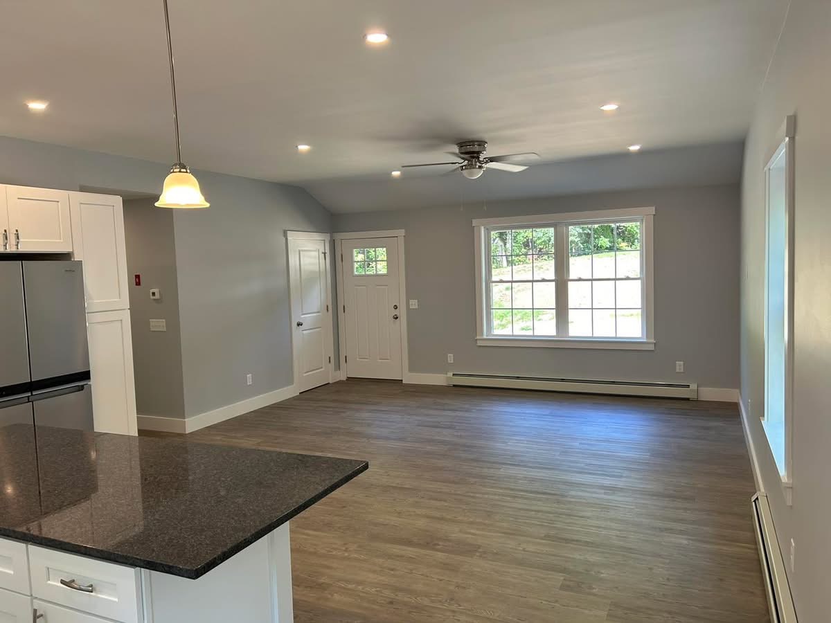 Open living area with vaulted ceiling, recessed lighting, and vinyl plank flooring