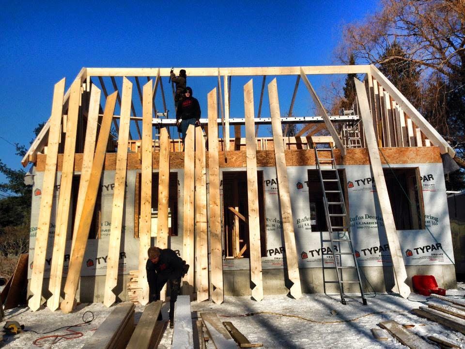 Crew framing walls and rafters on a new home build in winter