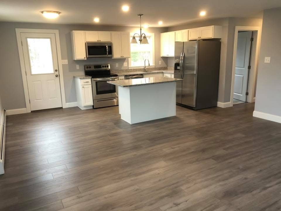 Open-concept kitchen remodel with granite island and wide-plank flooring