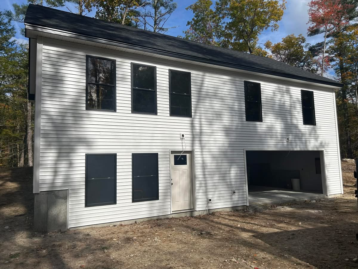 New white colonial home with black windows and attached garage