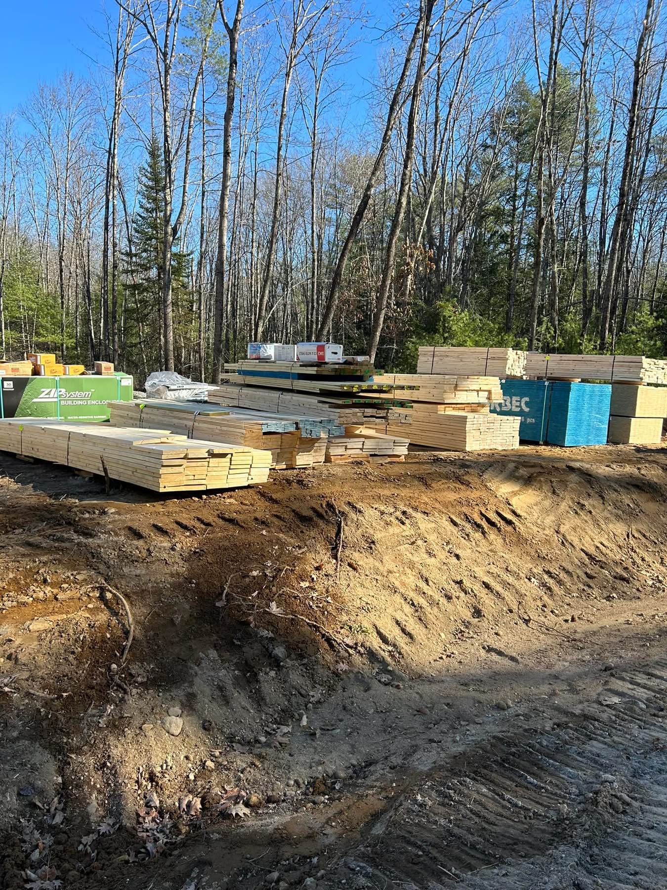 Framing lumber and building materials staged on a new construction site